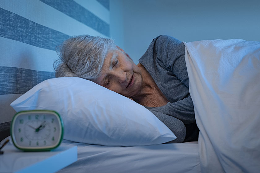 old woman grey hair sleeping peacefully night time bed senior