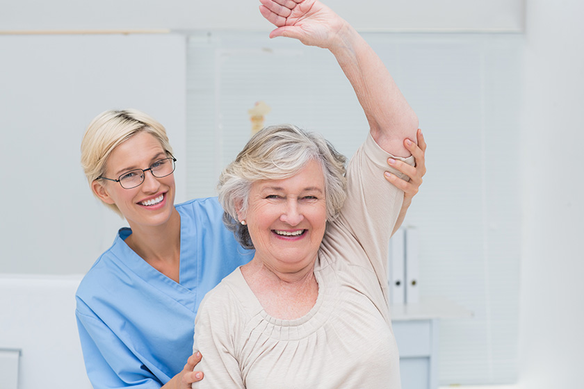 patient being assisted by nurse in raising arm