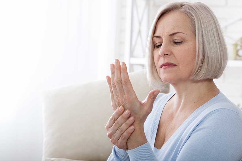 woman massaging her arthritic hand and wrist