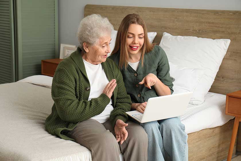 young woman her grandmother using laptop bedroom young woman her grandmother using laptop bedroom
