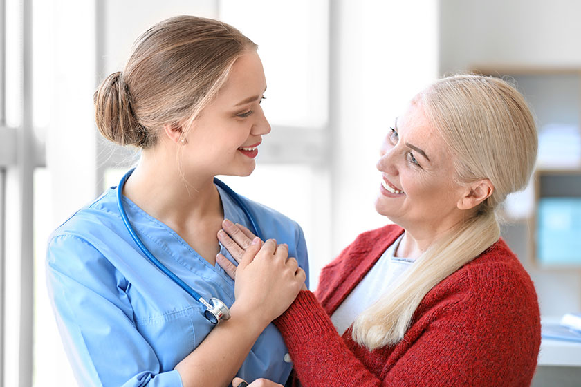 medical assistant with mature patient in clinic
