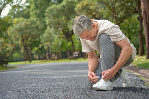 senior man tying shoelace getting ready exercise