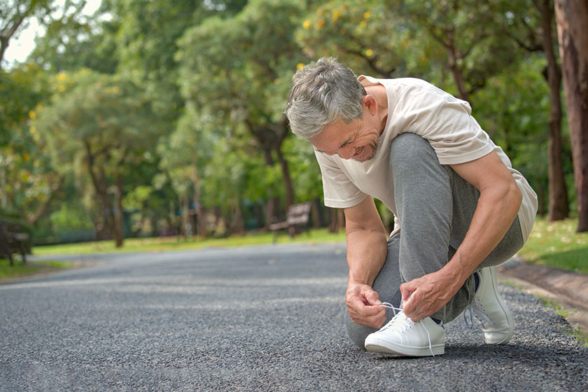 senior man tying shoelace getting ready exercise