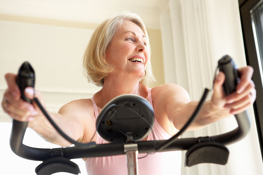 senior woman on exercise bike senior woman on exercise bike