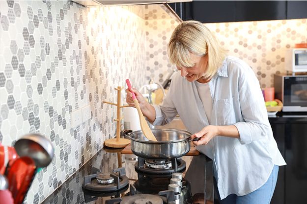 caucasian elderly wife making food in kitchen during her retirement life and happy holiday