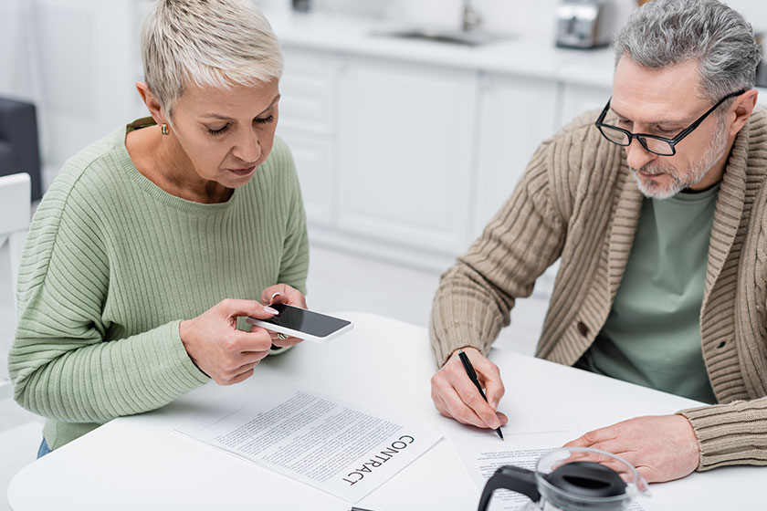 elderly woman taking photo contract husband document coffee kitchen
