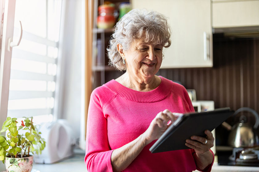 happy senior woman using digital tablet home
