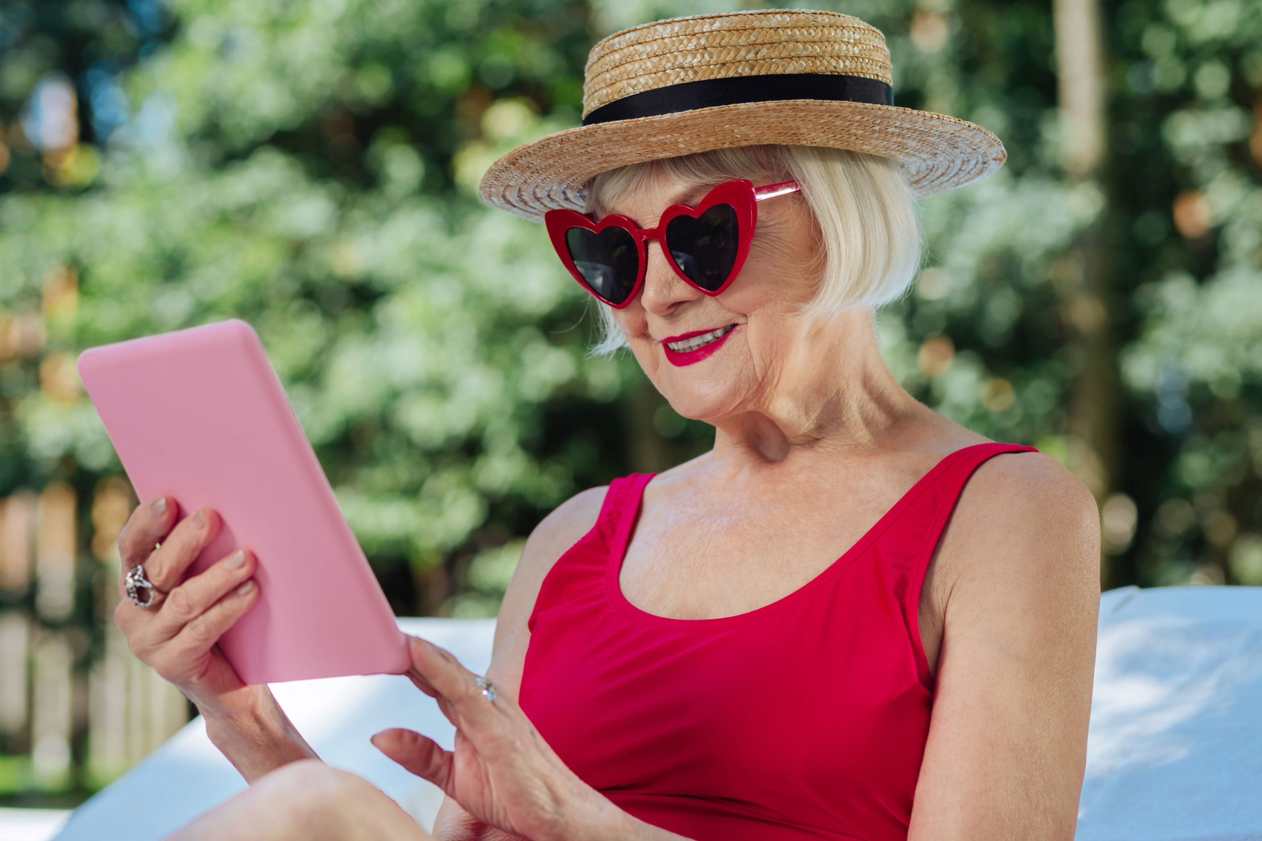 mature woman with red lips reading electronic book on laptop  scaled