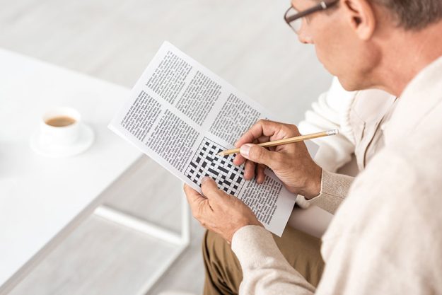 selective focus senior man dyslexia holding pencil crossword