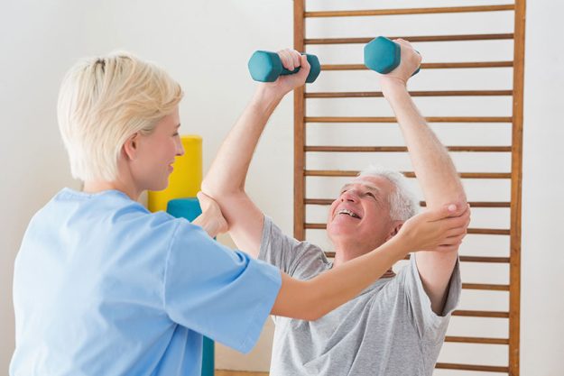 senior man working out with his therapist