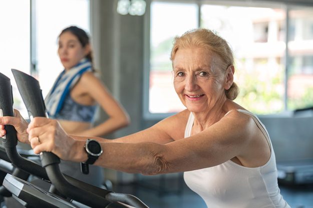 senior woman exercising spinning bike fitness gym elderly healthy lifestyle