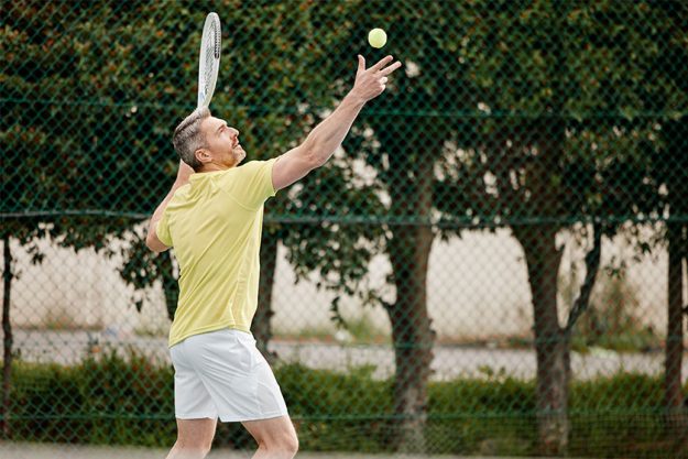 a handsome mature male tennis player serving a handsome mature male tennis player serving