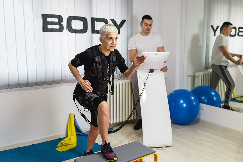 beautiful senior woman doing exercises electrical muscular stimulation suit her