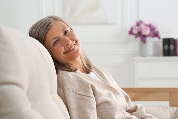 beautiful senior woman sofa home space text