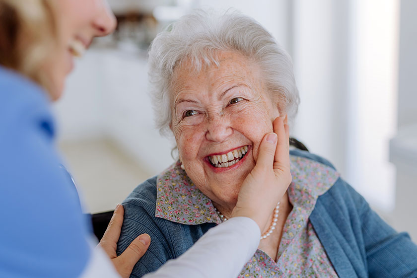 close nurse stroking cheek senior woman
