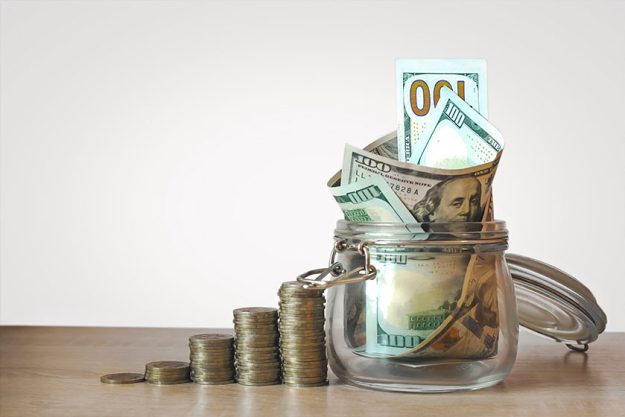 coins stack and us dollar bills in the glass jar coins stack and us dollar bills in the glass jar