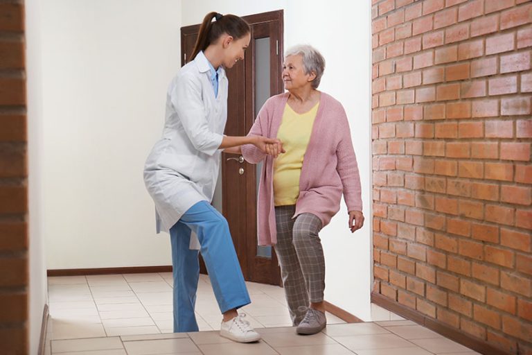 doctor helping senior patient at modern clinic