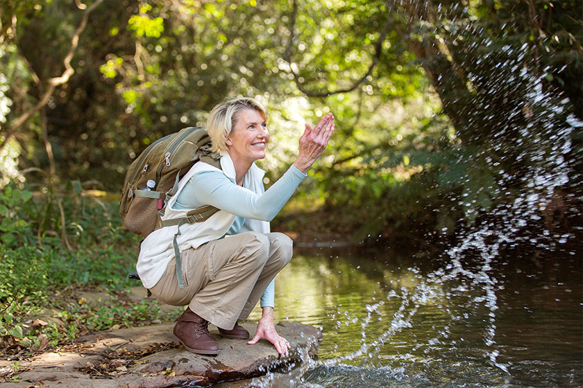 female hiker playing with stream water female hiker playing with stream water