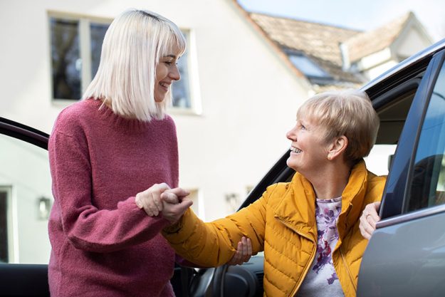 female neighbor giving senior woman a lift in car