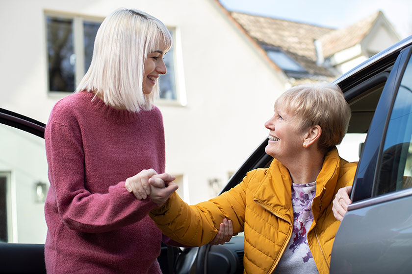 female neighbor giving senior woman a lift in car