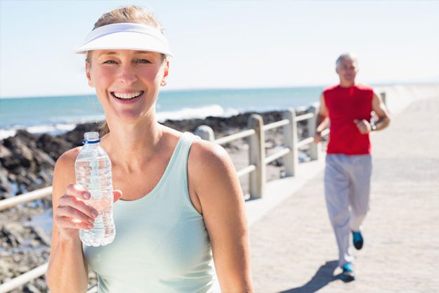 fit mature couple jogging together on the pier