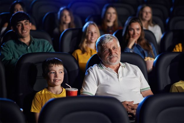 grandfather with grandson in cinema hall grandfather with grandson in cinema hall