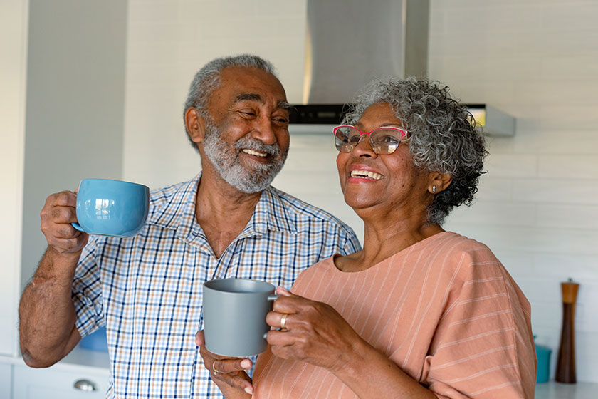 happy african american senior couple holding mugs coffee talking healthy