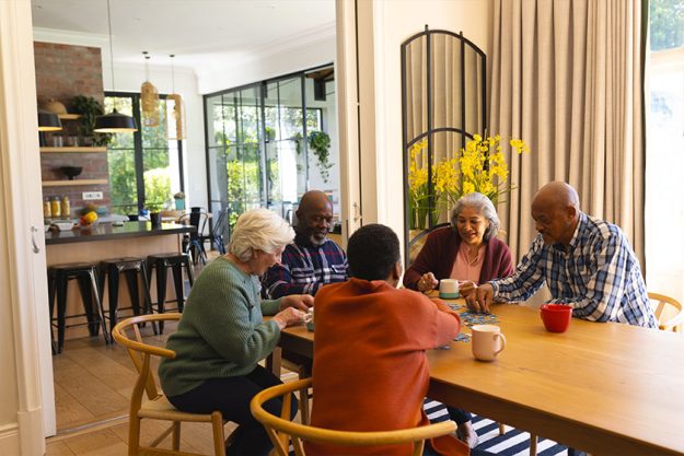 happy diverse group senior friends playing jigsaw puzzles