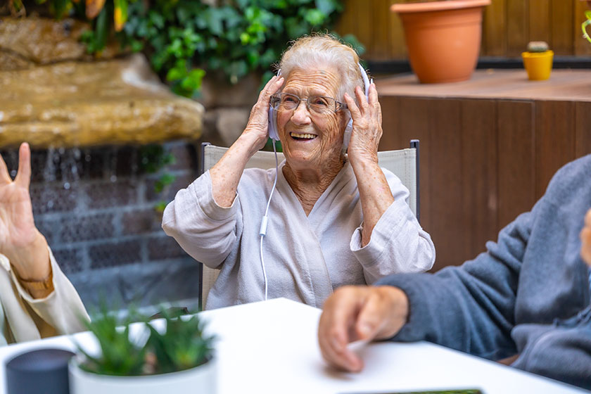 happy seniors using headphones having fun nursing home