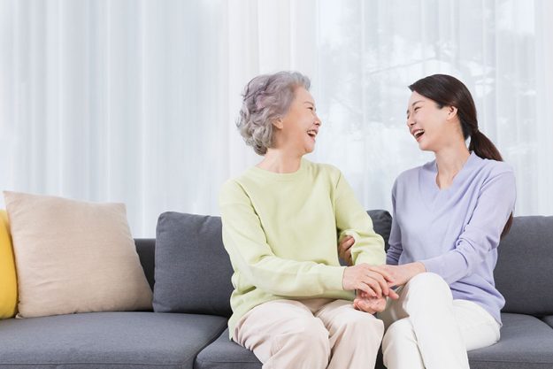 happy smiling asian old mother middle aged daughter sofa 