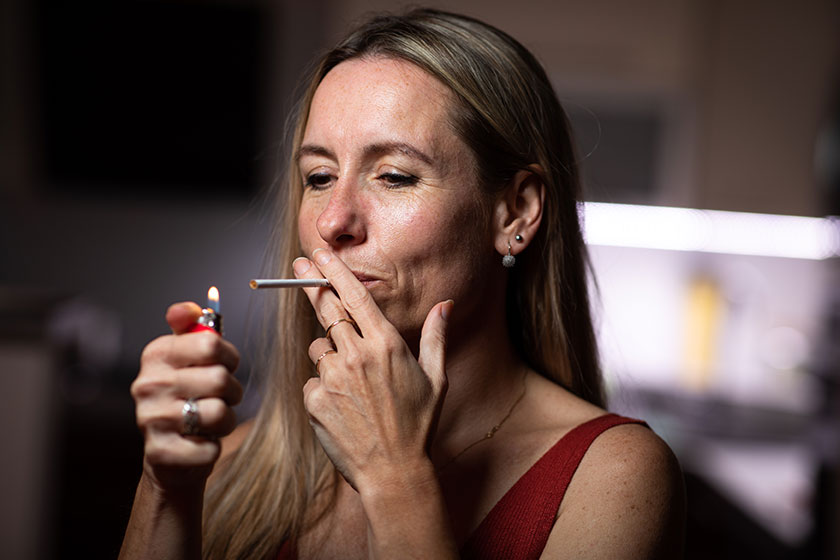 mid aged woman lighting cigarette home getting her nicotine daily mid aged woman lighting cigarette home getting her nicotine daily