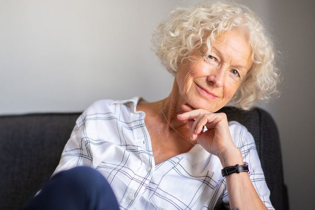 portrait smiling older woman relaxing sofa home 