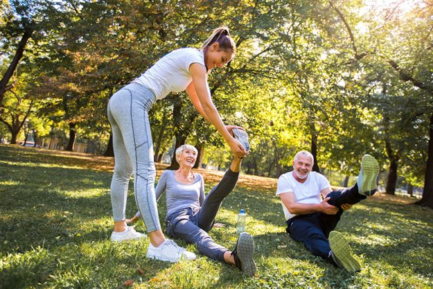 senior man woman young female instructor workout fresh air outdoor