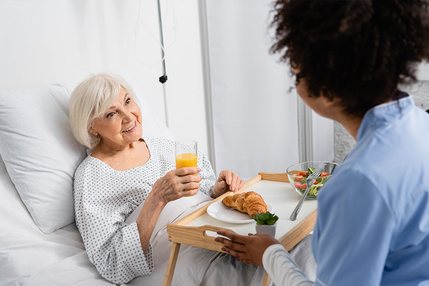 smiling elderly patient with glass of orange juice