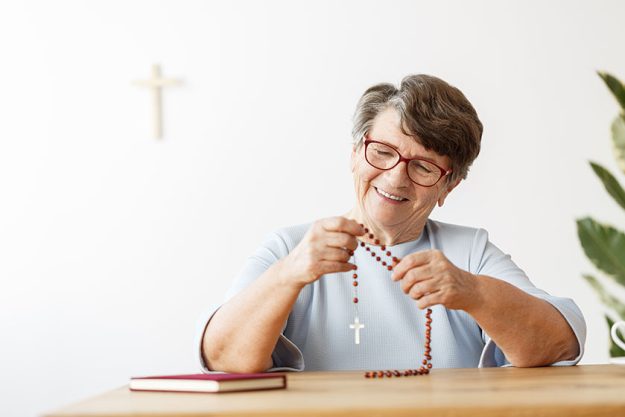 smiling senior woman with rosary smiling senior woman with rosary