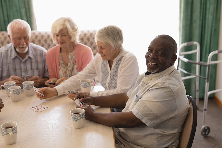 front view group happy senior people playing cards living room front view group happy senior people playing cards living room
