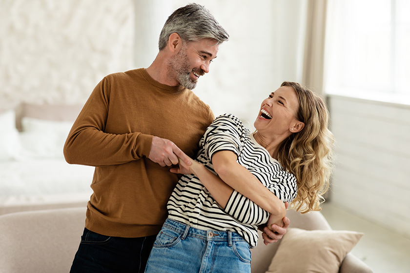 joyful couple dancing and laughing having fun at home
