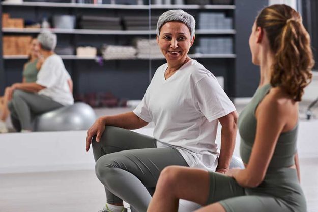 mature woman exercising fitness ball together instructor health club