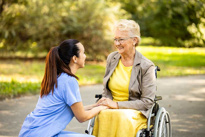 nursing assistant taking care elderly woman wheelchair