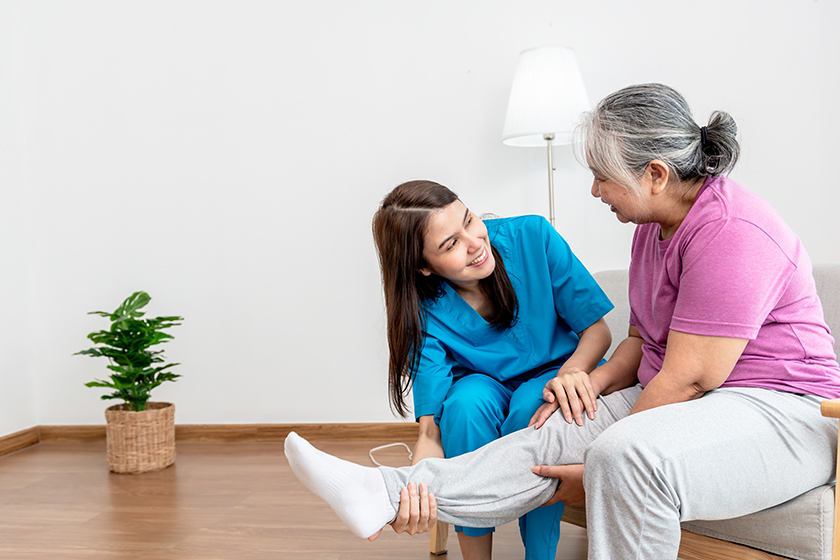 physical therapist asian woman doing leg physiotherapy elderly woman treat