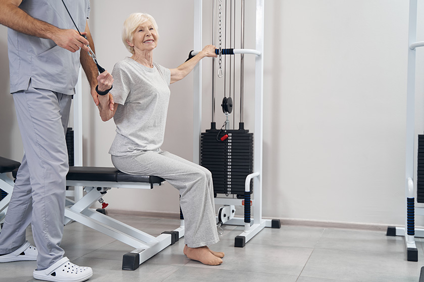 pleased elderly woman pulling handle and cable of strength machines pleased elderly woman pulling handle and cable of strength machines