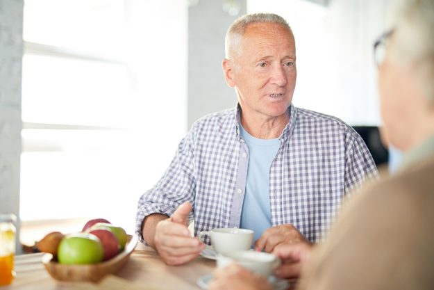 senior man casualwear sitting table having tea talking his wife