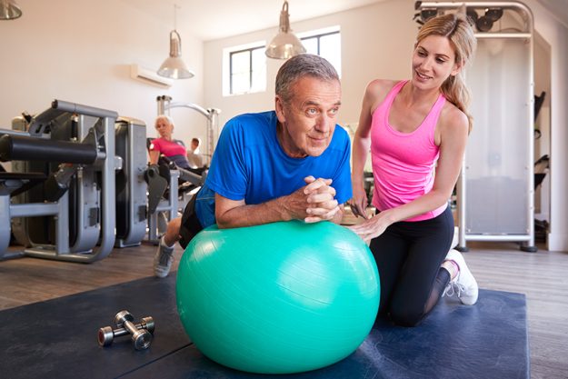 sport gym people adult man workout big ball female trainer sport gym people adult man workout big ball female trainer