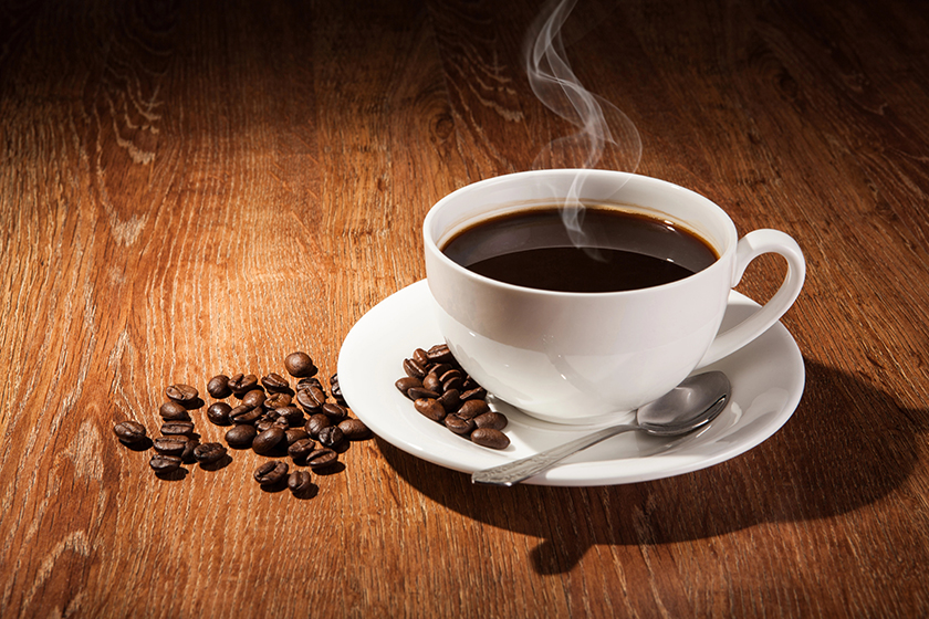still life with a cup of black coffee and roasted coffee beans