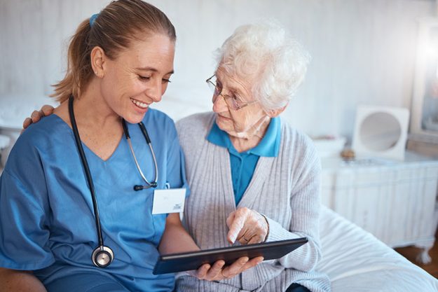tablet nurse doctor consulting old woman nursing home bedroom blood 