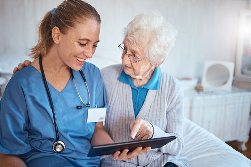 tablet nurse doctor consulting old woman nursing home bedroom blood 