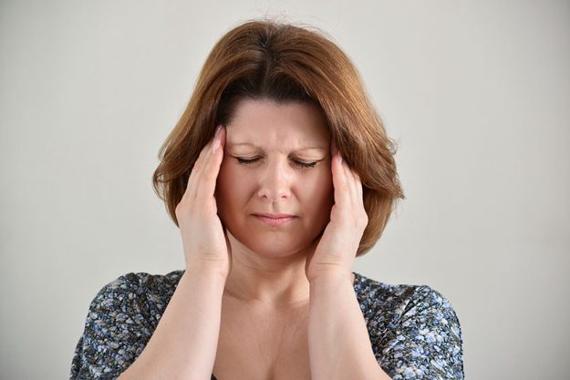woman holding hands on head depression pain migraine woman holding hands on head depression pain migraine