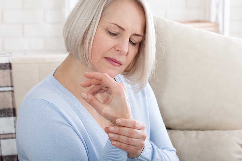 woman massaging her arthritic hand and wrist