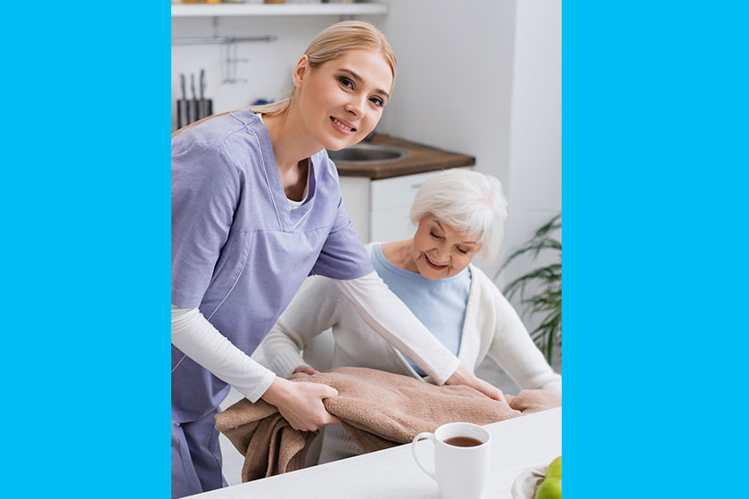 young nurse smiling camera while covering senior woman soft blanket young nurse smiling camera while covering senior woman soft blanket