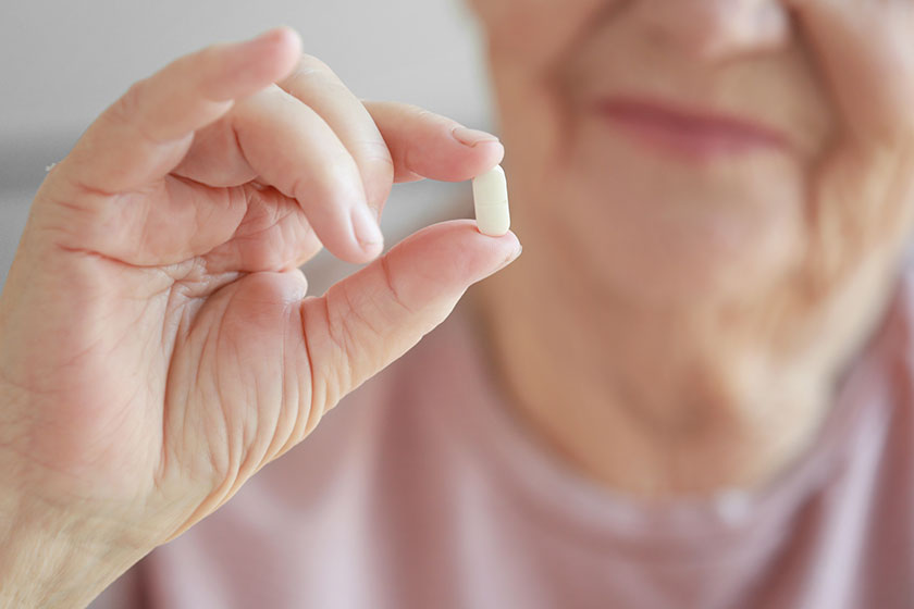 elderly woman with pill